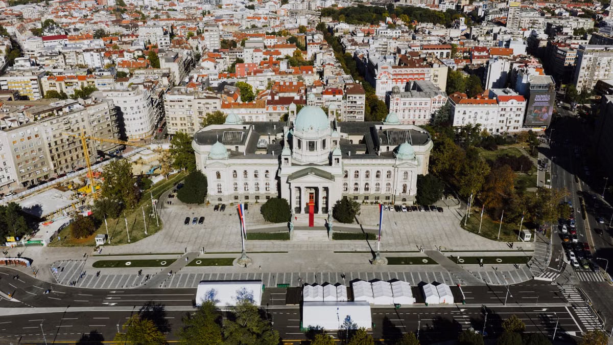 Drone shot of the National Assembly building in Belgrade, Serbia’s architectural landmark surrounded by cityscape.